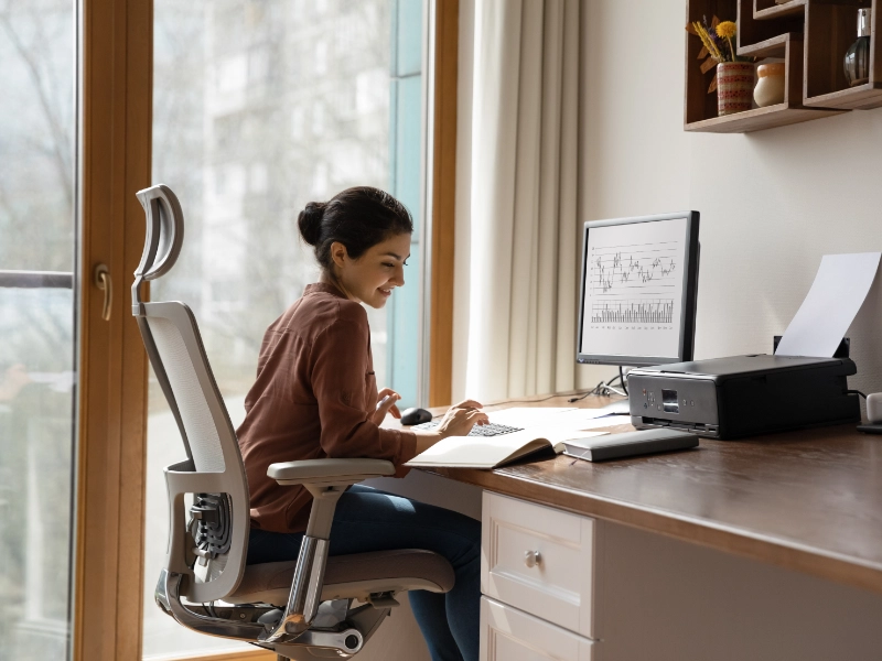 woman behind desk working on a computer