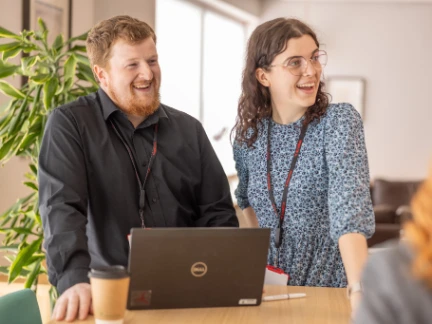 Two Atradius colleagues sharing a comment in a breakout area