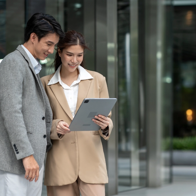 Two Business people working on a tablet outside office