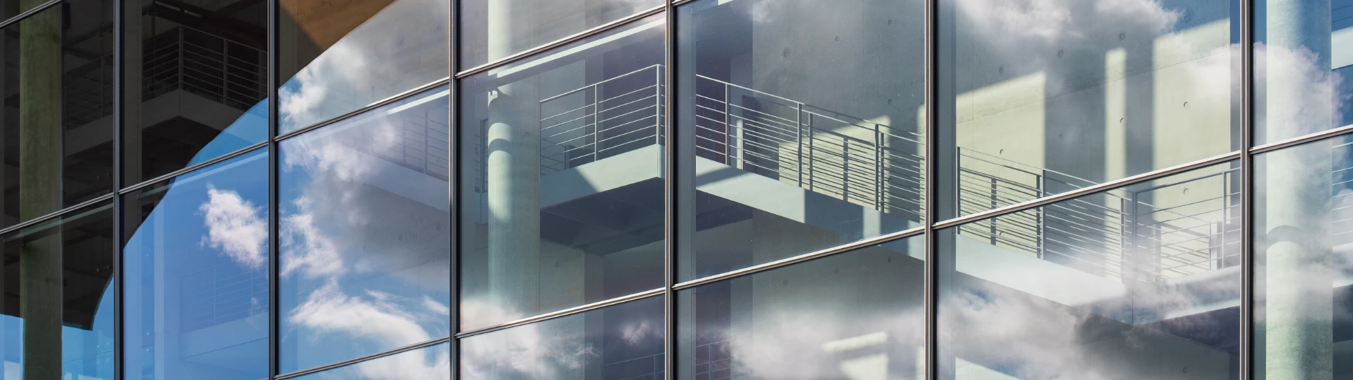 cloudy sky reflected in a modern glass facade building