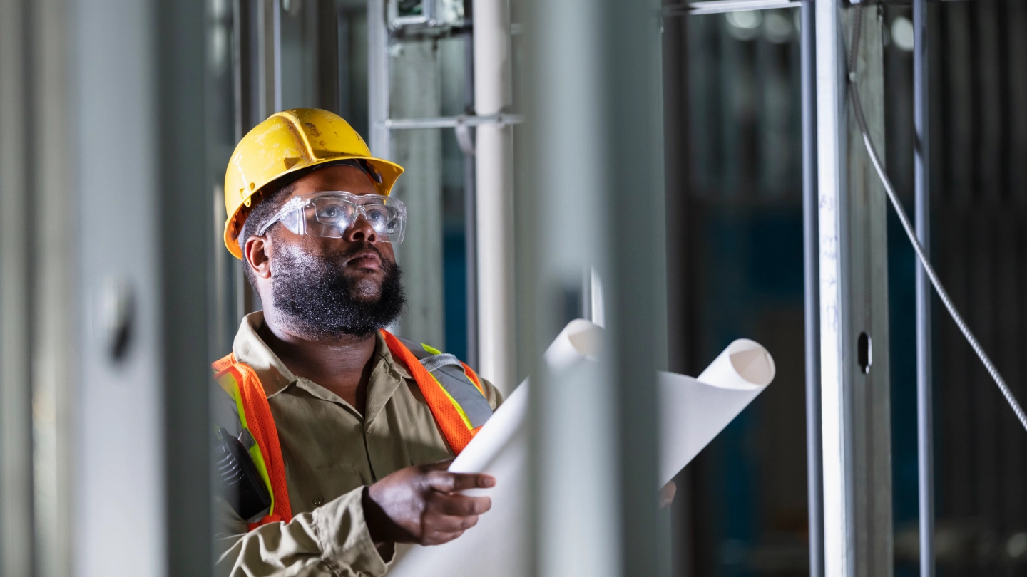 construction worker reviewing drawings image