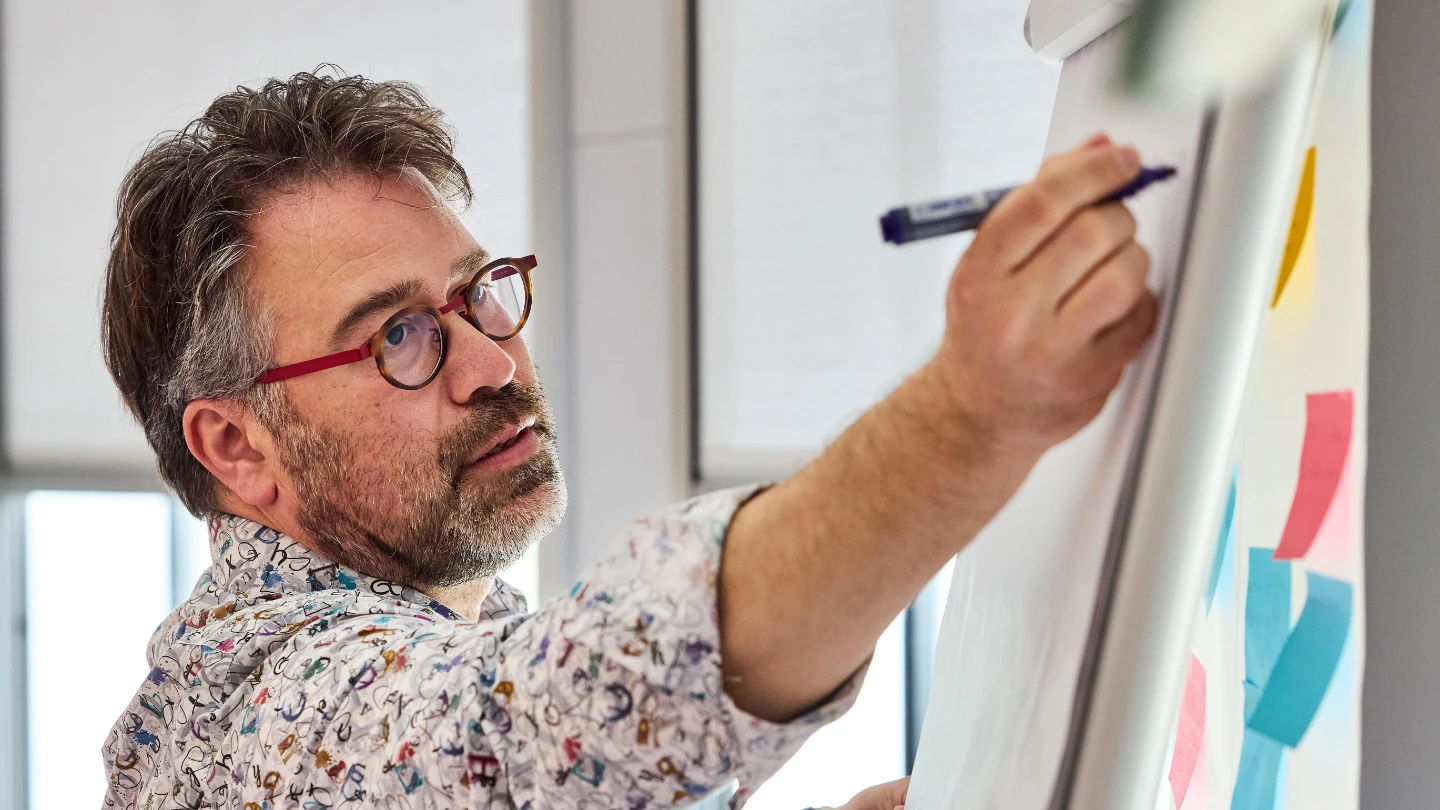 Atradius Man making notes on a flipchart at a workshop