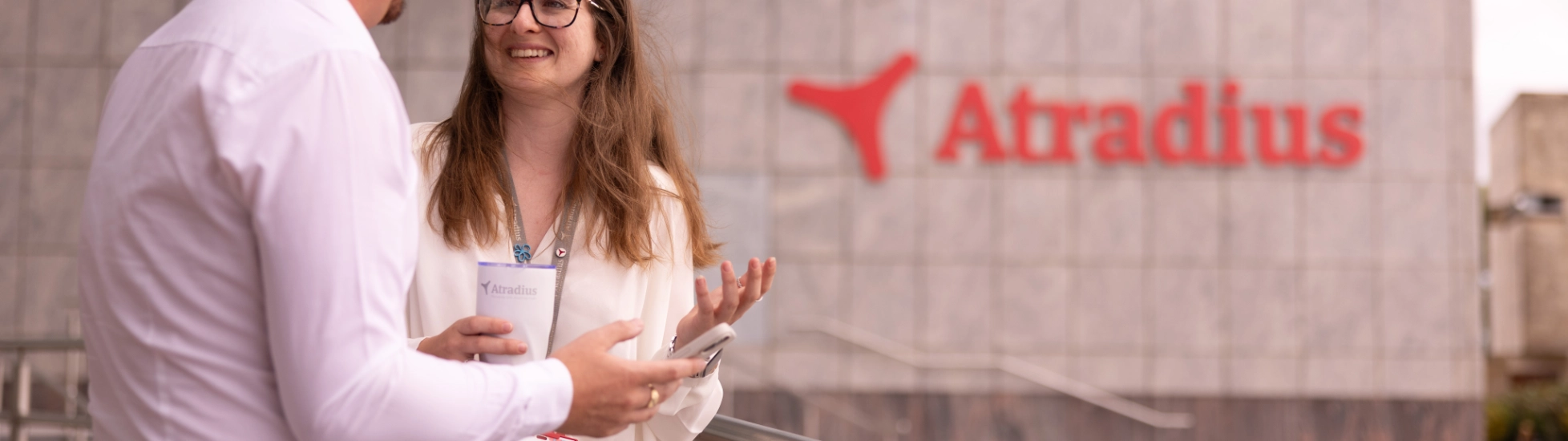 Woman and man have coffee break outside at the entrance of the Cardiff office