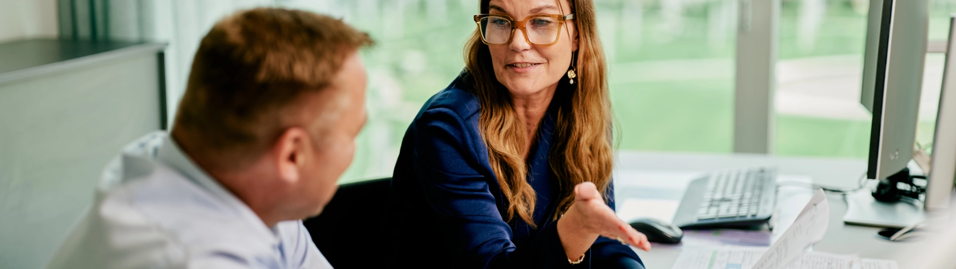 Woman and man discussing sitting at a desk