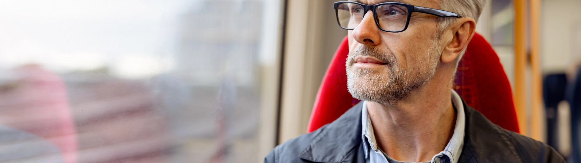 man on a train holding a mobile phone