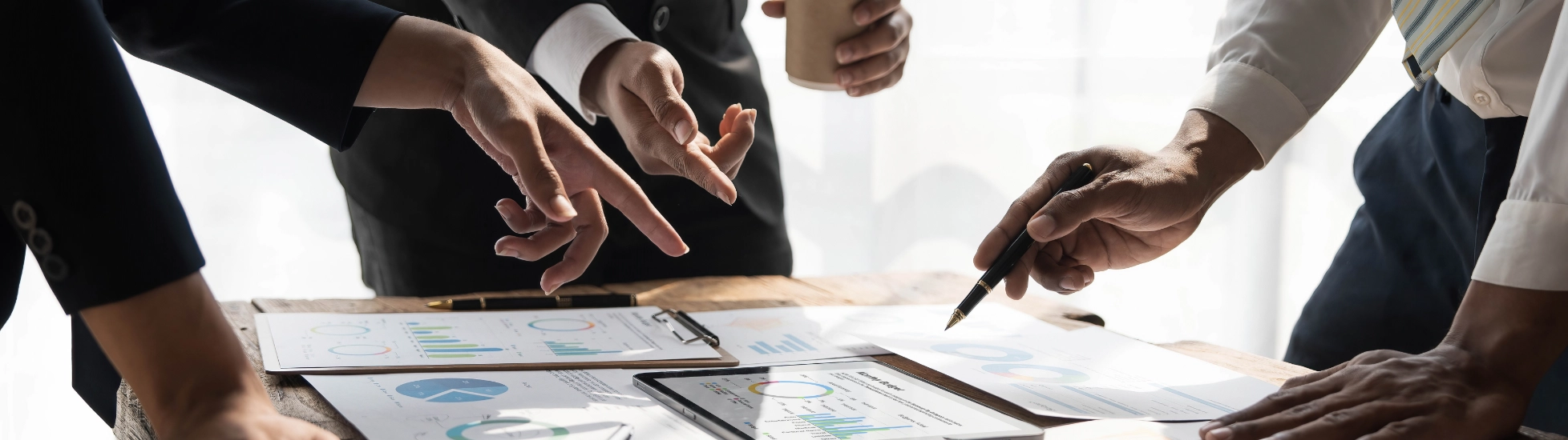 business people in meeting discussing strategy on tablet and laptop