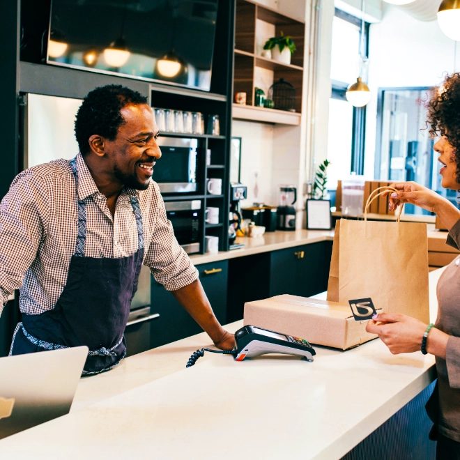 Man and woman at a cashier desk smiling