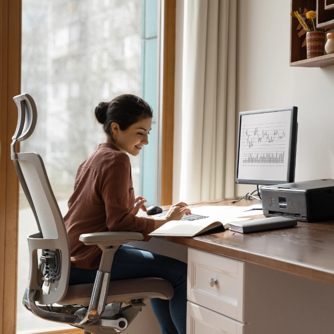 woman behind desk working on a computer