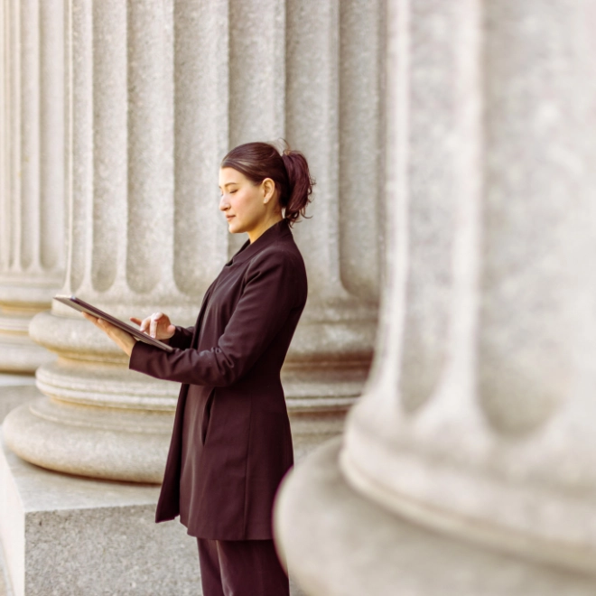 Businesswoman standing outside bank working on a tablet