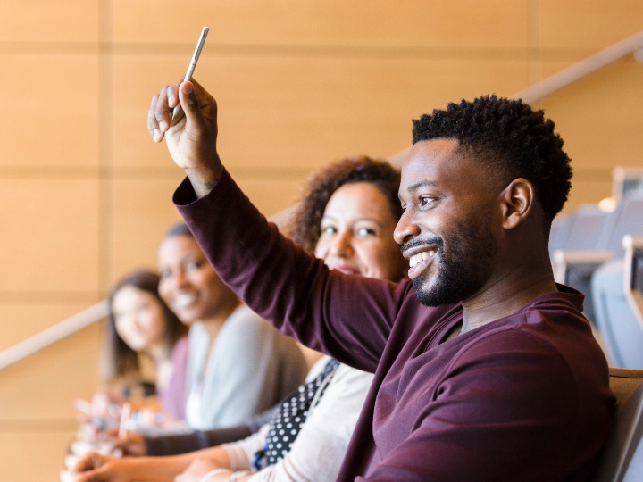 Man raising his hand to ask a question